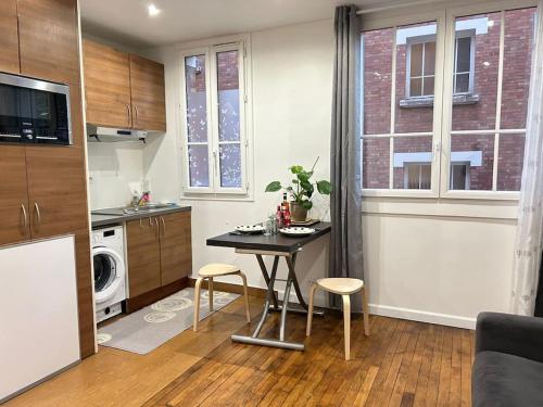 une cuisine avec une table et des chaises dans une pièce dans l'établissement Parc Montsouris - Longue durée, à Paris