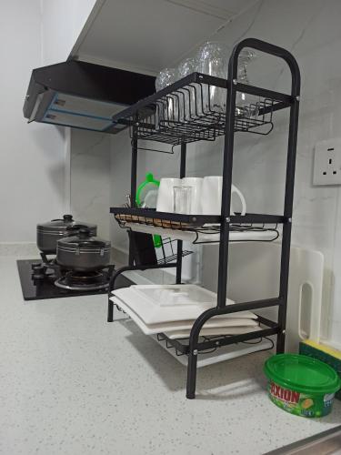 a shelf in a kitchen with dishes and pots and pans at Bela Homes Large Deluxe studio Apartment in Nairobi