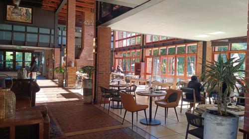 a restaurant with tables and chairs and people sitting at tables at Riboville Boutique Hotel And Restaurant in Midrand