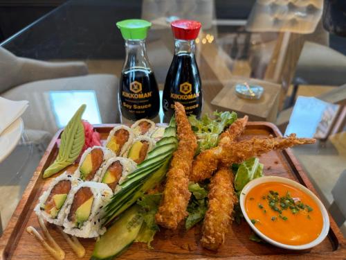 a tray of food with french fries and salad and two bottles of sauce at Riboville Boutique Hotel And Restaurant in Midrand