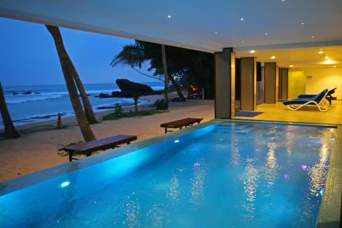 a swimming pool in a house with a view of the ocean at Sayura Beach Hotel in Unawatuna