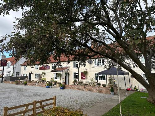 a white building with an umbrella in front of it at Wellington Studio Retreat in Northallerton in Northallerton