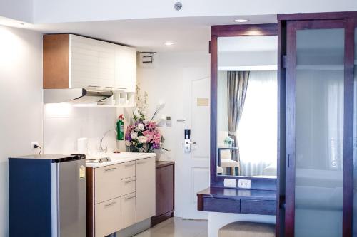 a kitchen with a sink and a refrigerator in it at Romance Hotel Bangna in Bangkok