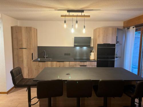 une cuisine avec une table et des chaises dans une pièce dans l'établissement L'Etoile Blanche - Appt vue montagne, à Flumet