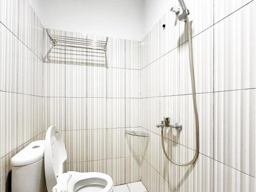 a bathroom with a shower and a toilet at RedDoorz at Krisan Kendari in Pulupanda
