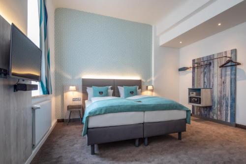 a bedroom with a bed with a blue wall at Holiday Inn - the niu, Rig Lübeck by IHG in Lübeck