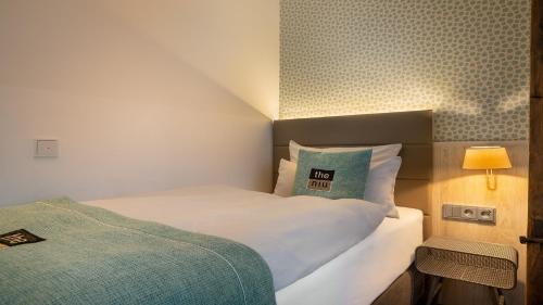 a bedroom with a bed with a pillow and a lamp at Holiday Inn - the niu, Rig Lübeck by IHG in Lübeck