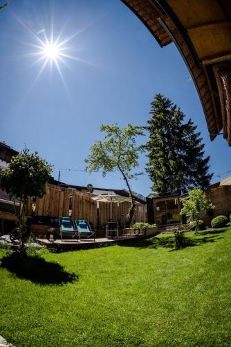 a yard with two chairs and a fence at ALPENHOTEL TYROL - B&B - ADULTS ONLY - Alpines Lifestyle-Konzepthotel - dog friendly in Pertisau
