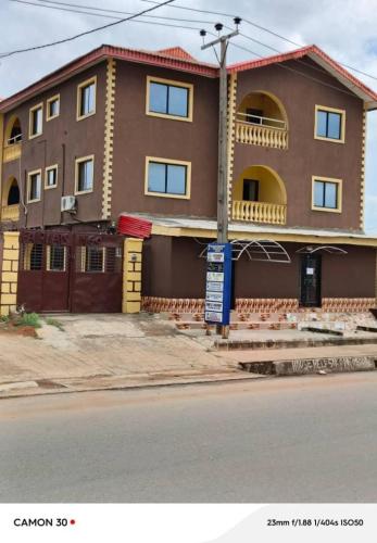 a brown house with a sign in front of it at Fairways Apartments in Otta