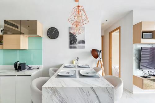 a kitchen and dining room with a marble table and chairs at Hyde Sukhumvit 11 Bangkok in Bangkok