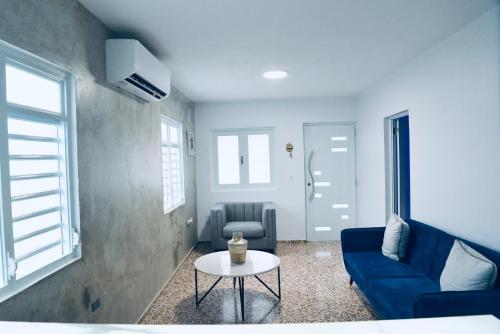 a living room with a blue couch and a table at GD Vacation Rentals in Arecibo