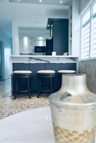 a kitchen with two stools and a counter in a kitchen at GD Vacation Rentals in Arecibo