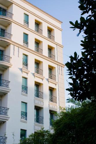 a tall white building with balconies on it at Romance Hotel Bangna in Bangkok