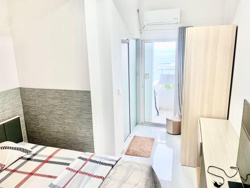 a bedroom with a bed and a large window at Dhonveli Stay in Hulhumale