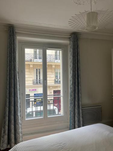 - une chambre avec une fenêtre donnant sur un bâtiment dans l'établissement Cozy appartement near Opera and Galeries Lafayette Haussmann, à Berthouvilliers