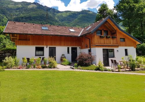 a wooden house with a green lawn in front of it at Mölltaler Muglhof in Kolbnitz