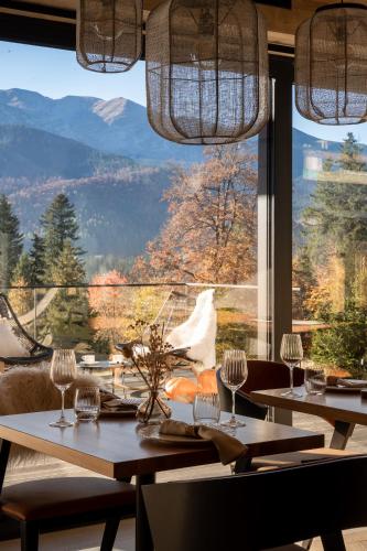 a dining room with tables and a large window at Villa La Roca Garden and Spa in Kościelisko