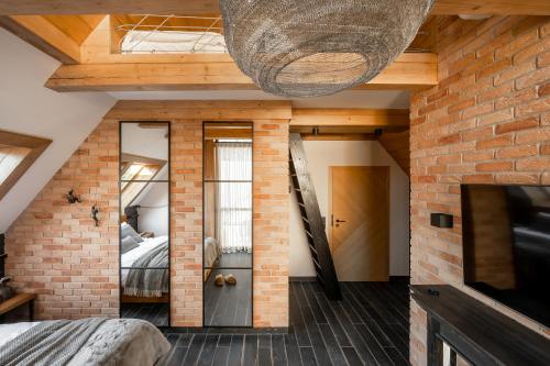 a room with a bed and a brick wall at Villa La Roca Garden and Spa in Kościelisko