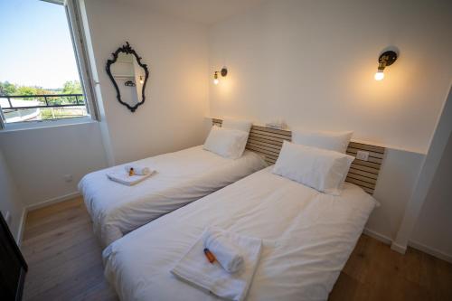 two beds in a room with white sheets at L'Odissée in Mazeray