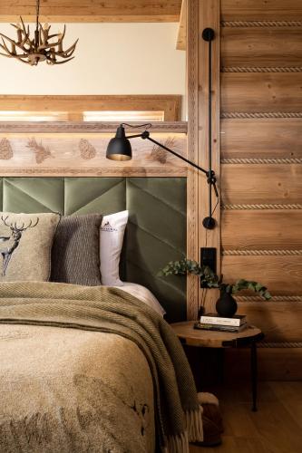 a bedroom with a bed and a lamp on a table at Villa La Roca Garden and Spa in Kościelisko