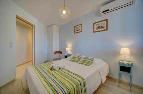 - un chien blanc dormant sur un lit dans une chambre dans l'établissement LUMINEUX 3 PIECES RENOVE FACE AU PORT l! A2B218, à Cannes