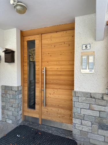 porta d'ingresso in legno di una casa di Appartamento Edera ad Aprica
