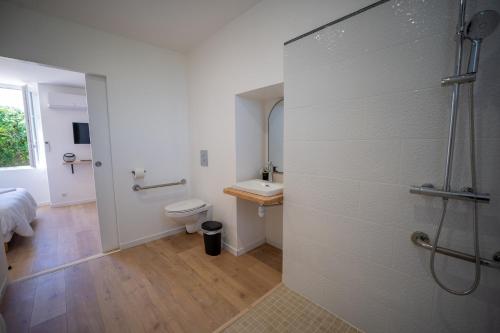 a bathroom with a shower and a toilet and a sink at L'Odissée in Mazeray