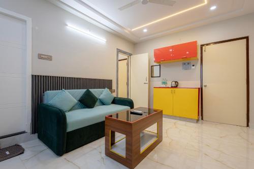Una sala de estar con un sofá verde y una mesa. en Hotel wood land grand, en Guntūr