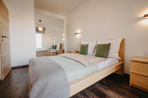 Un dormitorio con una gran cama blanca con almohadas verdes. en Arad City Escape AFI Mall, en Arad