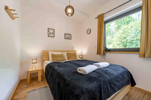 シュチルクにあるApartament Solisko 3 Modrzewiowy Z widokiem na góry - Dream Apartのベッドとタオル2枚のある寝室