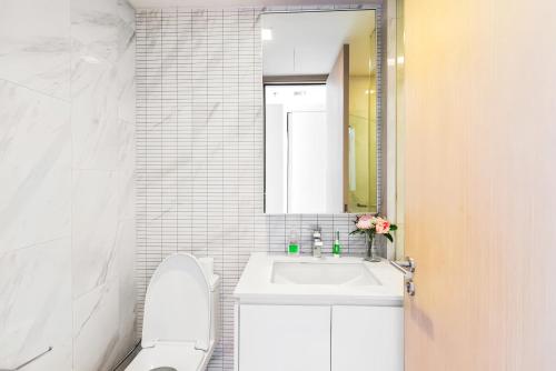 a bathroom with a sink and a toilet and a mirror at Hyde Sukhumvit 11 Bangkok in Bangkok