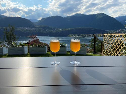 two glasses of beer sitting on a table with a view at Residence Belvedere & Private Beach in Omegna