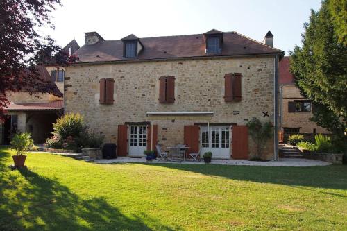 a large brick house with a lawn in front of it at L'écrin de verdure - Vue imprenable - Piscine in Cénac-et-Saint-Julien