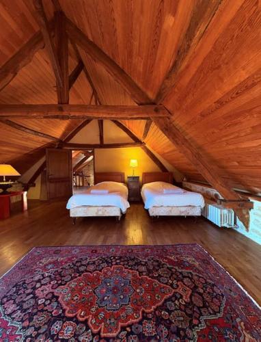 Cette grande chambre comprend 2 lits et un tapis. dans l'établissement L'écrin de verdure - Vue imprenable - Piscine, à Cénac-et-Saint-Julien