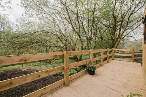 a wooden porch with a fence and a potted plant at A Place In the Pennines in Huddersfield