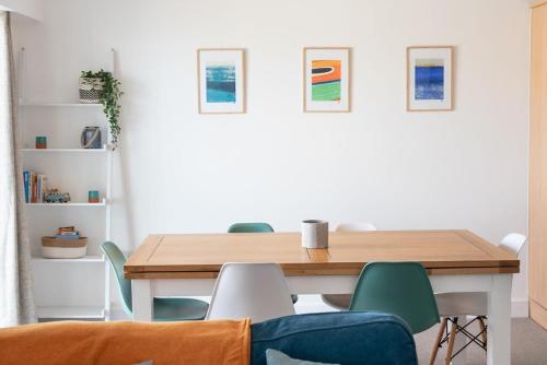 a dining room with a wooden table and chairs at Spacious Flat Sea Views & Private Parking Fistral in Newquay