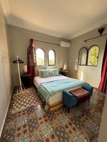 a bedroom with a large bed and two windows at Belle villa Baldi à la campagne d'Essaouira in Essaouira