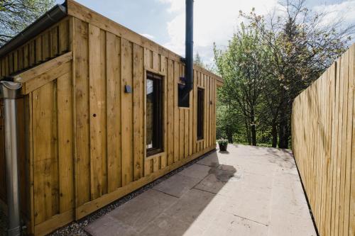 a wooden building next to a fence at A Place In the Pennines in Huddersfield