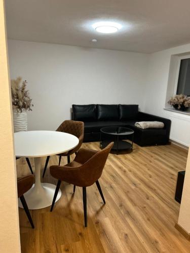 a living room with a black couch and a table at Alex Design-Apartment in Jettingen-Scheppach