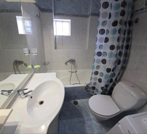 a bathroom with a sink and a toilet and a tub at Calliestia 7 in Chios