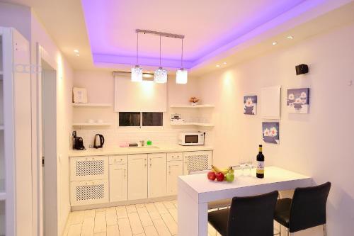 a kitchen with a table and a purple ceiling at סוויטות דה בלנקה in Had Nes