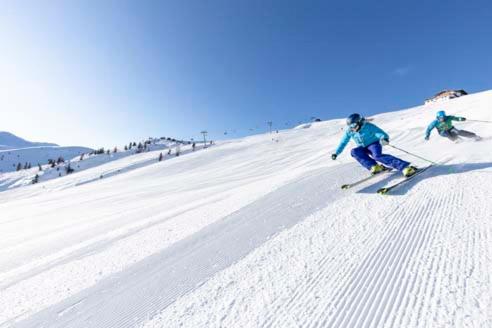 two people are skiing down a snow covered slope at Penthouse Sonnenplatzl in Radfeld