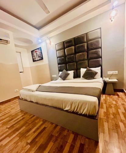 a bedroom with a large bed with a large headboard at Hotel Airport City in New Delhi