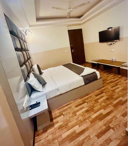 a bedroom with a bed and a flat screen tv at Hotel Airport City in New Delhi