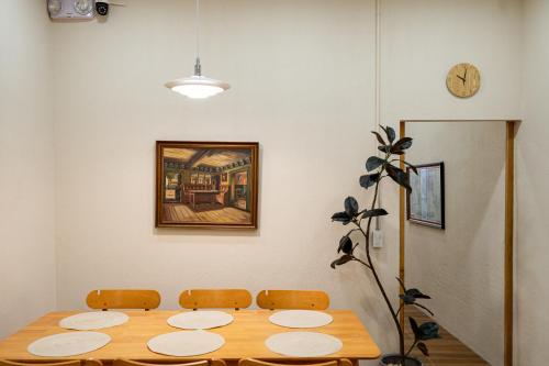 a dining room with a wooden table and a clock at Yimwhan House 03, Chao Phrom Market Pier in Phra Nakhon Si Ayutthaya