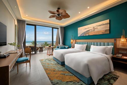 two beds in a hotel room with a view at Angsana Quan Lan, Ha Long Bay in Quan Lạn