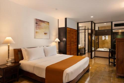 a bedroom with a large bed and a bathroom at Jetwing Beach in Negombo