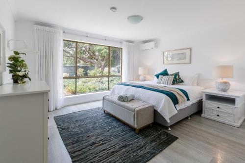 a white bedroom with a bed and a window at Capewood - Coastal Family Retreat in Prevelly in Prevelly