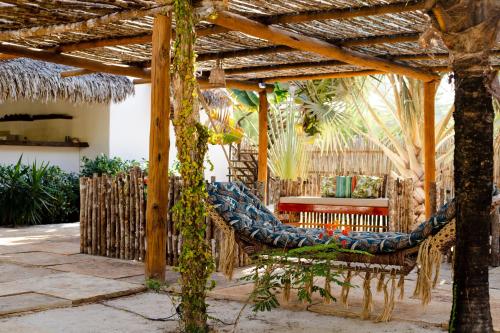 a patio with a hammock under a wooden pergola at A Piscina Itaca in Barrinha