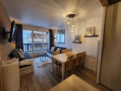 une cuisine et un salon avec une table et des chaises dans l'établissement La Roche Noire - Ski au pied de l'immeuble, à Valmeinier
